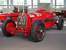 Photo d'une Alfa Romeo P2 de 1930 plus récente que la précédente et exposée dans un musée avec des numéros de course peint sur la calandre.