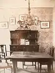 Une salle à manger avec table chaises et lustre suspension.