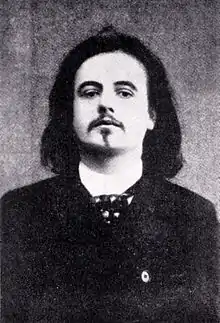 Photographie noir et blanc d'un homme aux cheveux longs.