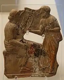Terre cuite de 480-460 av. J.‑C., provenant d'une tombe de Mélos et conservée au British Museum. On suppose qu'il s'agit de l'une des plus anciennes représentations de Sappho, ici tenant un barbitos, en conversation avec un homme, peut-être Alcée.