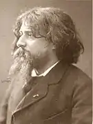 Portrait photographique sépia d'un homme aux cheveux longs et à la barbe en bataille.