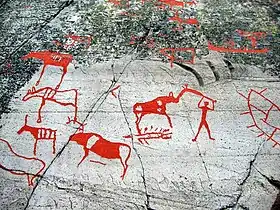 Dessins rouge vifs sur des pierres, représentants des animaux et un homme les chassant