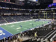 Vue de loin du terrain de l'Amalie Arena avec quelques joueurs. Public clairsemé dans les tribunes.