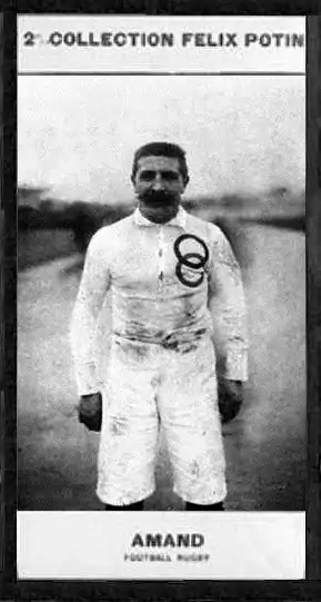 Portrait en demi grandeur d'un homme moustachu en maillot blanc avec les anneaux olympiques brodés sur la poitrine.