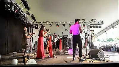 Mark Glanville (en) frappe avec une baguette une bouteille en verre au WOMAD avec le groupe Amaraterra