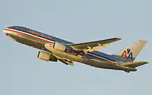 Vue latérale d'un 767 en montée initiale dans un ciel blue clair. Des lignes bleue, blanche et rouge courent sur toute la longueur du fuselage ; au-dessus est écrit « American ». L'empennage vertival arbore deux « A », entre lesquels se trouve un aigle simplifié.