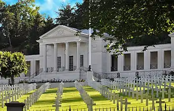 Photographie en couleur représentant un cimetière au premier plan et une chapelle au second plan.