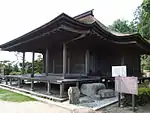 Un bâtiment en bois avec une grande véranda à l'avant.