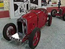 Photographie d'une automobile rouge exposée dans un salon.