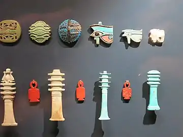 Amulettes égyptiennes : le pilier Djed aux côtés de l'Oeil d'Horus et du Nœud d'Isis. Musée du Louvre.