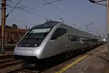 Un train Alfa Pendular de couleur grise et fraichement peint entre en gare.