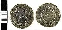 Photo des deux faces d'une pièce de monnaie, avec le buste d'un homme couronné de profil d'un côté et une petite croix de l'autre