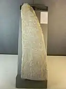 Imposante pierre taillée en forme de dent avec des grandes inscriptions gravées dessus.