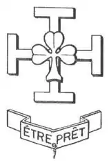 Dessin d'une croix de Jérusalem portant un trèfle à trois feuilles en son centre. Au-dessous dans un bandeau la mention ETRE PRET