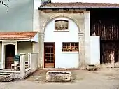 Photographie d'un cadre de porte de l'ancienne abbaye dans un mur moderne.