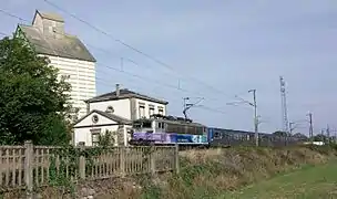 Une rame réversible régionale tractée par la BB 25607 passe devant l'ancienne gare de Mommenheim.