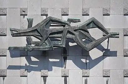 La justice poursuivant le mal, œuvre monumentale sur la façade du palais de justice de Charleroi (1964).