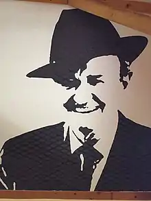 Fresque en noir et blanc d'un homme souriant avec un chapeau.