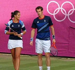 Deux joueurs de tennis, une femme et un homme, se tiennent côté à côté, en tenue.