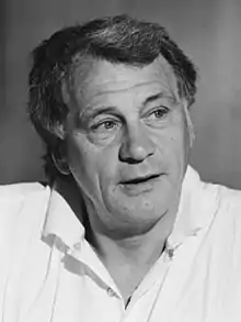 Photographie en noir et blanc. Portrait de Bobby Robson en chemise blanche, regardant vers sa gauche.