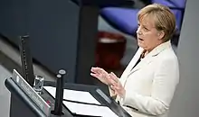 Photographie en couleurs d'Angela Merkel s'exprimant devant le Bundestag, le 10 septembre 2014