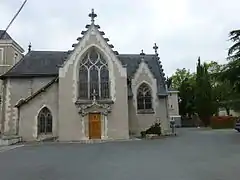 Photographie d'une petite chapelle à pignons, crépi à dominante gris-beige.