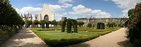  Photographie panoramique de jardins ; un châtelet et une chapelle à l'arrière-plan.