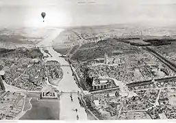 Photographie aérienne d'une ville, un ballon se trouve dans les airs.