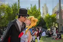 Photographie d’un jeune homme déguisé en personnage de Tuxedo Mask et d’une jeune fille déguisée en Sailor Moon.