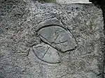 Un chrisme gravée sur une pierre à l'entrée du cimetière et de l'église Saint-Étienne.