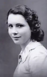 Photo noir et blanc d'une jeune femme en buste, souriante, brune