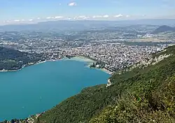 Vue aérienne d'Annecy avec sur la gauche le site du Boubioz à droite de la pointe du Semnoz s'avançant dans le lac.