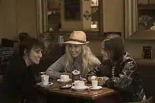 Photographie de trois femmes à une table dans un café.