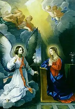 Peinture. L'ange aux ailes déployées présente un lys à Marie, en pière. Plusieurs anges les observent au sommet.