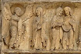 Bas-relief. À gauche, l'ange fait face à la Vierge ; à droite, Élisabeth tient la main de Marie.
