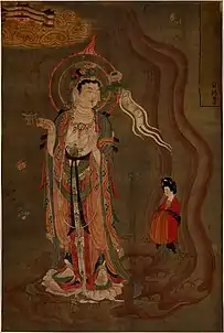 Bodhisattva montrant la voie. Vers 875; couleurs sur soie, 80.5 × 53,8 cm. Trouvé à Dunhuang (Grottes de Mogao, grotte 17). Le bodhisattva montre le chemin à une femme qui tient un brûle parfum dans sa droite et dans sa gauche une fleur de lotus, British Museum.