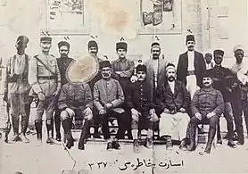 Prisonniers turcs (à dr.) surveillés par un officier français, un volontaire arménien et un tirailleur africain à Antep pendant la campagne de Cilicie, 1921