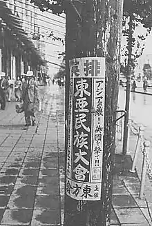 Affiche de propagande collée sur un poteau.