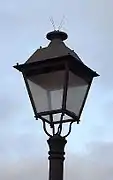 Lanterne classique à base carréemuni de pics anti-oiseauxposée sur un candélabre simpleEspagne
