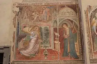 Peinture. L'ange et Marie sont placés dans un intérieur de style gothique. En haut, Dieu confie la palme à l'ange.