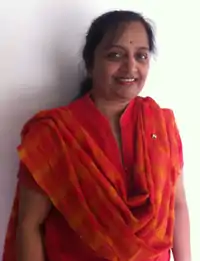 Photo en couleus d'une femme indienne souriante, en vêtement rouge.