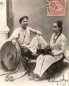 Photographie ancienne montrant deux femmes asiatiques assises, en habit traditionnel.