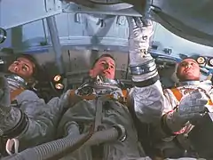 Photographie couleur de l'équipage d'Apollo 1 assis dans leur capsule.