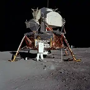 Buzz Aldrin enlevant le sismographe d'un compartiment du module.