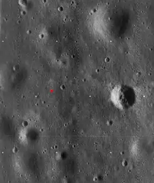 Image haute résolution de Lunar Orbiter 5, recadrée pour montrer le site d'atterrissage d'Apollo 11. Le site d'atterrissage est indiqué par un point rouge. Le cratère proéminent à droite est appelé cratère Ouest et mesure environ 190 m de diamètre.