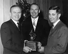 Photographie en noir et blanc des trois hommes d'Apollo 8 tenant ensemble le trophée Collier dans leurs mains.