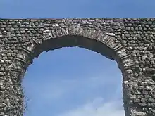 Vue de la voûte d'une arche d'un aqueduc, en briques et pierres alternées.