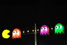 Sorte de lampadaire comportant les personnages Pac-Man et les fantômes, éclairant grâce à des ampoules.