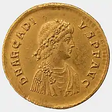 Avers d'une pièce de monnaie représentant le profil en buste d'un homme en toge et à la tête ceinte de lauriers.
