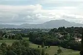 Vue d’un golf sur fond de montagnes.